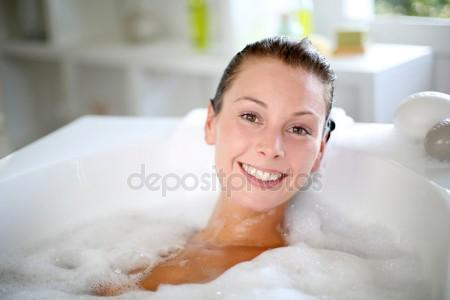 Улыбается женщина наслаждаясь принимать ванну Лицензионные Стоковые Фото