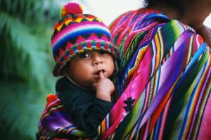 Chichicastenango, Guatemala --- Guatemalan Infant Carried on Mother's Back --- Image by © Sergio Pitamitz/CORBIS