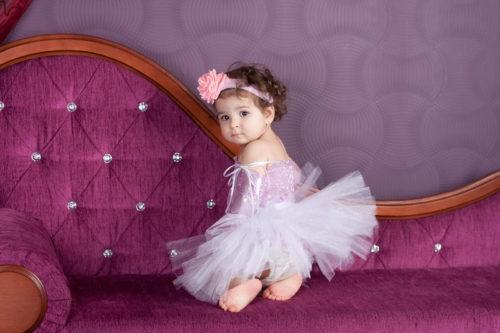 Маленькая девочка в пышном платье из фатина лавандового цвета